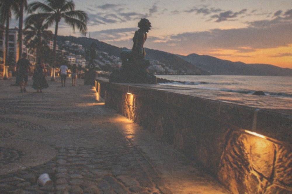Evening view of a seaside promenade with lights along the water