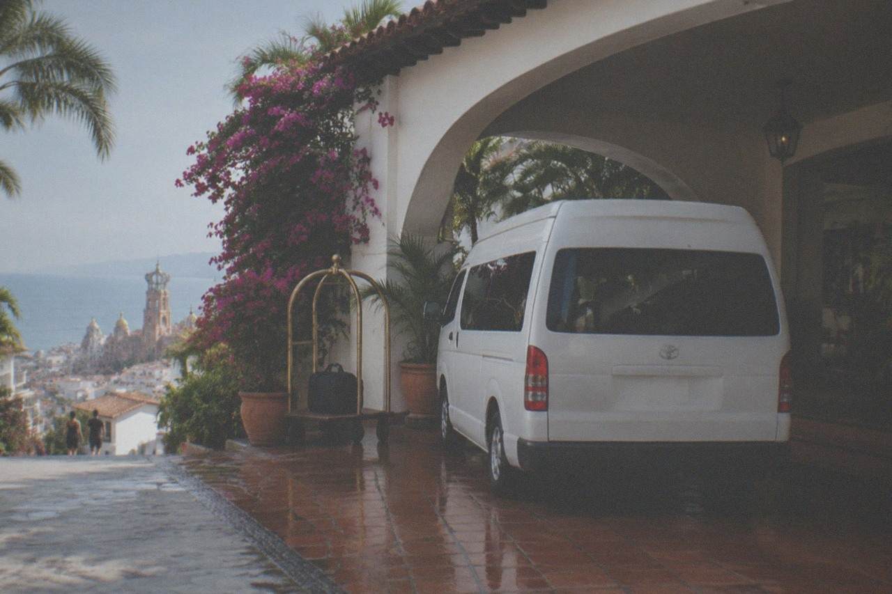 A hotel driveway in Puerto Vallarta with a tour van waiting at the entrance