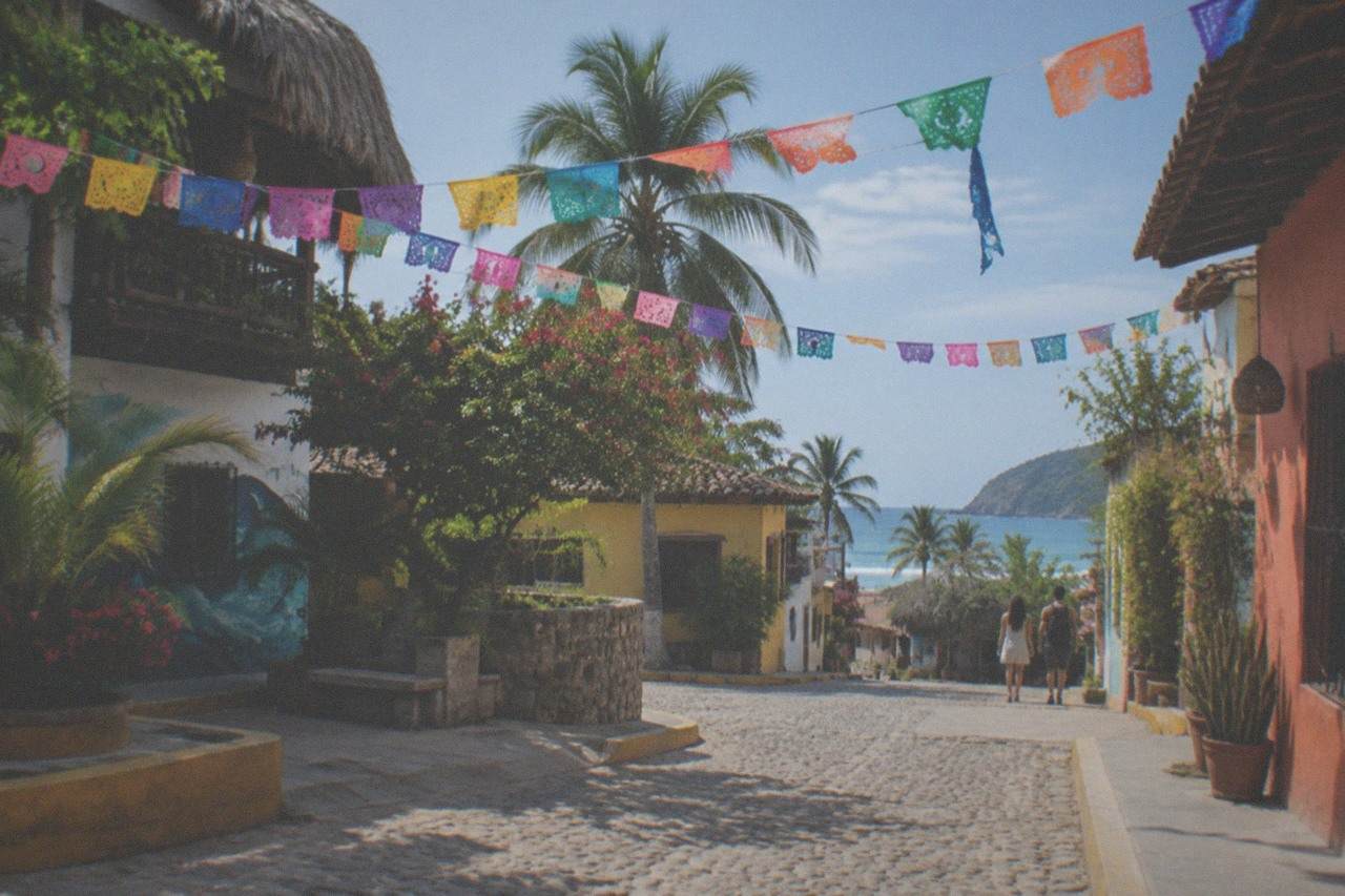 Colorful paper flag banners strung between painted buildings above a small town plaza