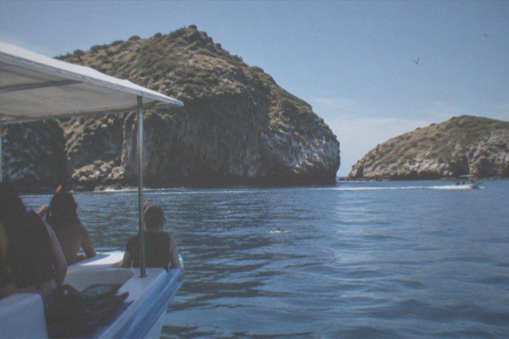 A snorkel boat anchored near rocky islands in calm blue water