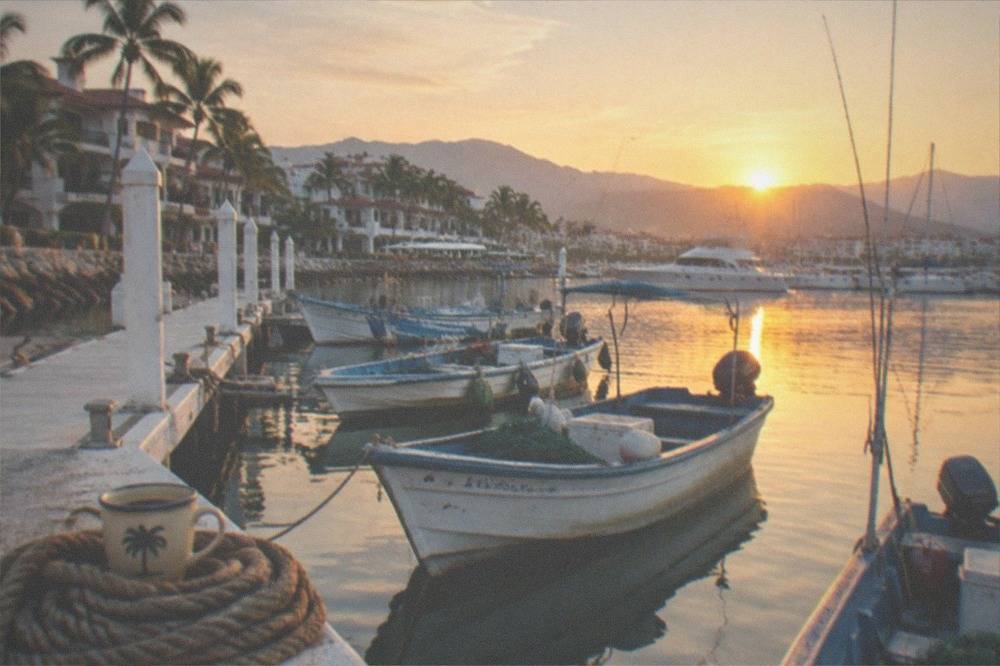 Fishing boats moored in a calm Puerto Vallarta marina at sunrise