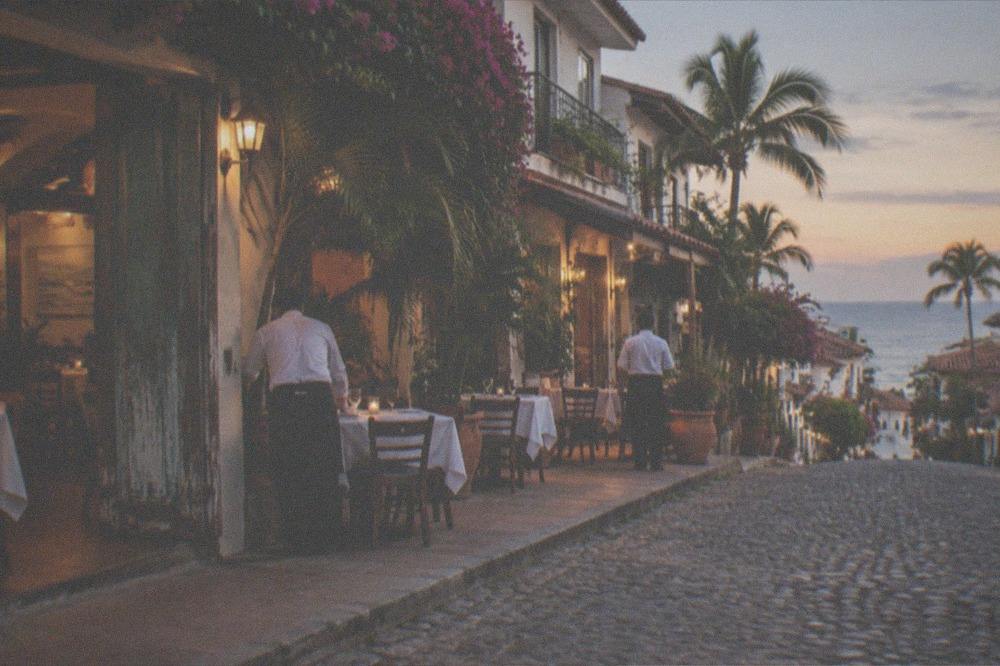 Evening crowd strolling past lit restaurants on a Puerto Vallarta street