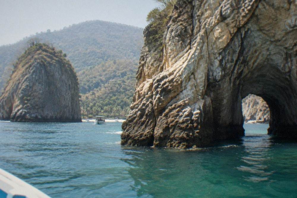 Towering granite rock formations of Los Arcos islands above clear green-blue water