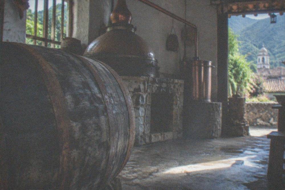 An oak barrel used for aging tequila in a rustic distillery