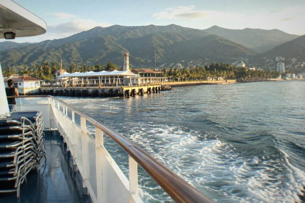 Large whale watching yacht cruising across Banderas Bay with mountains behind