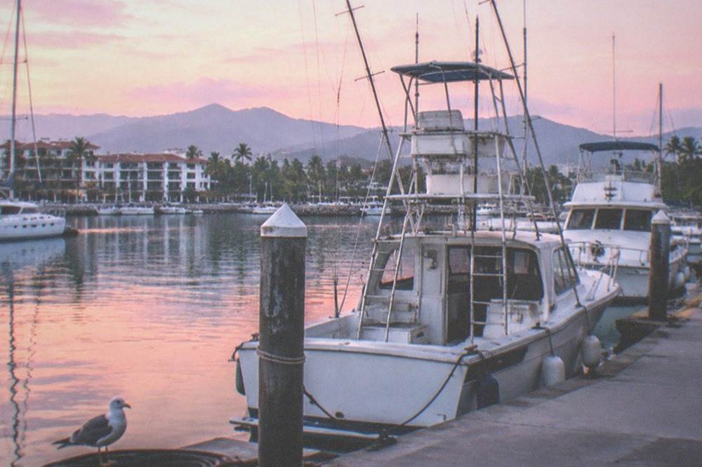 Tour boats moored at a marina in Puerto Vallarta in early morning light