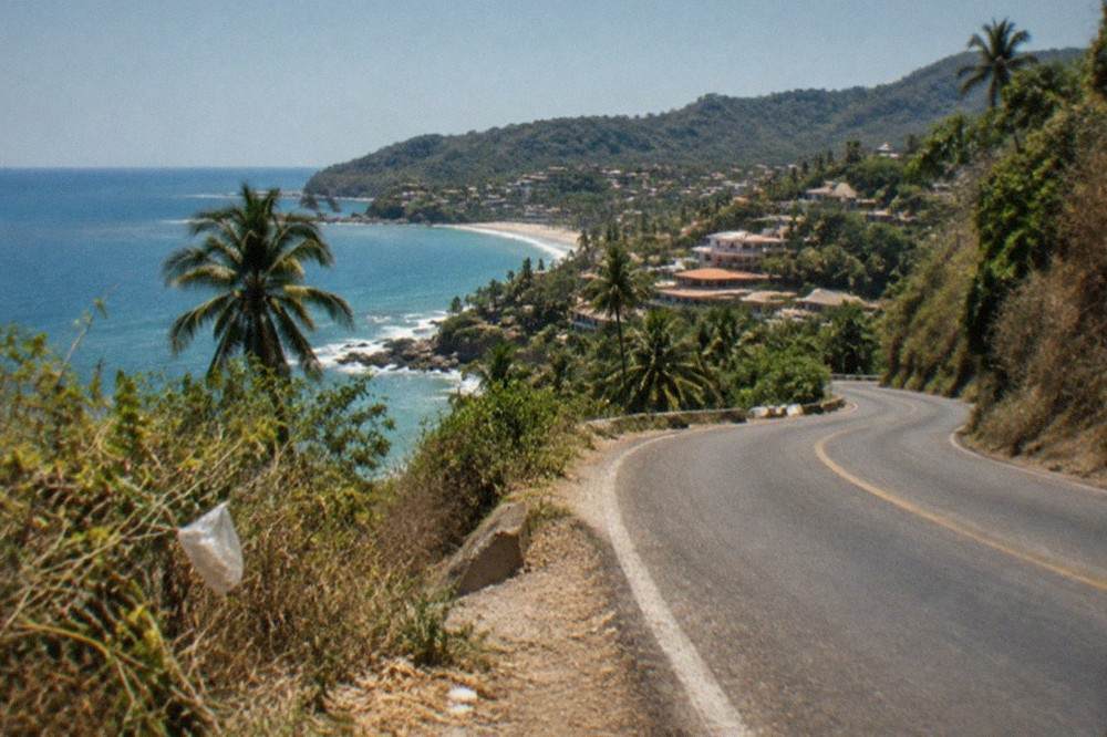 Winding coastal highway with jungle-covered hills above the ocean