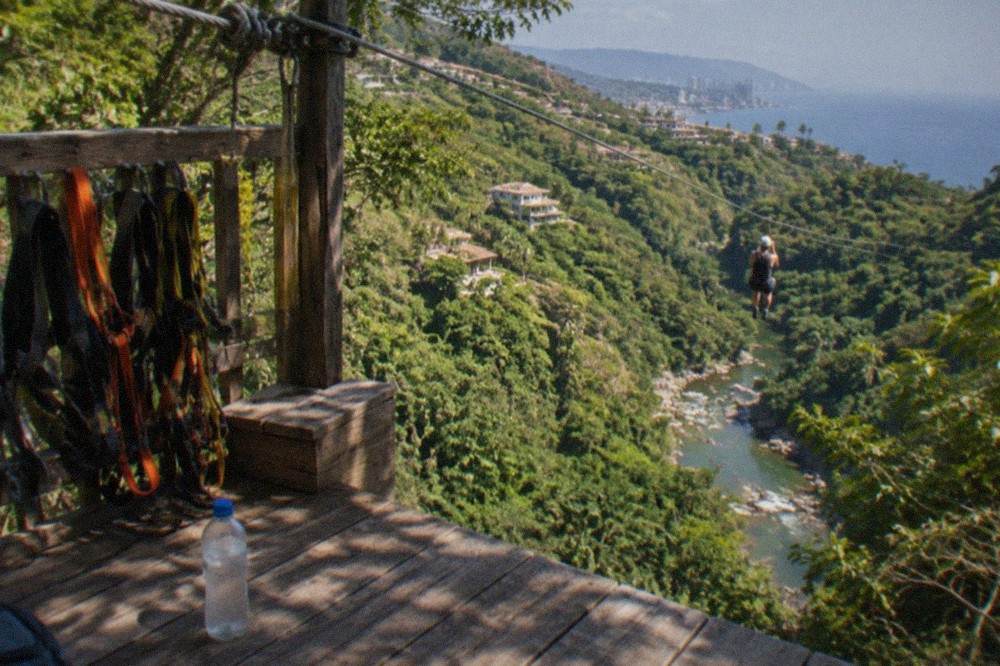 Treetop zipline platform overlooking a green river canyon in the Sierra Madre foothills