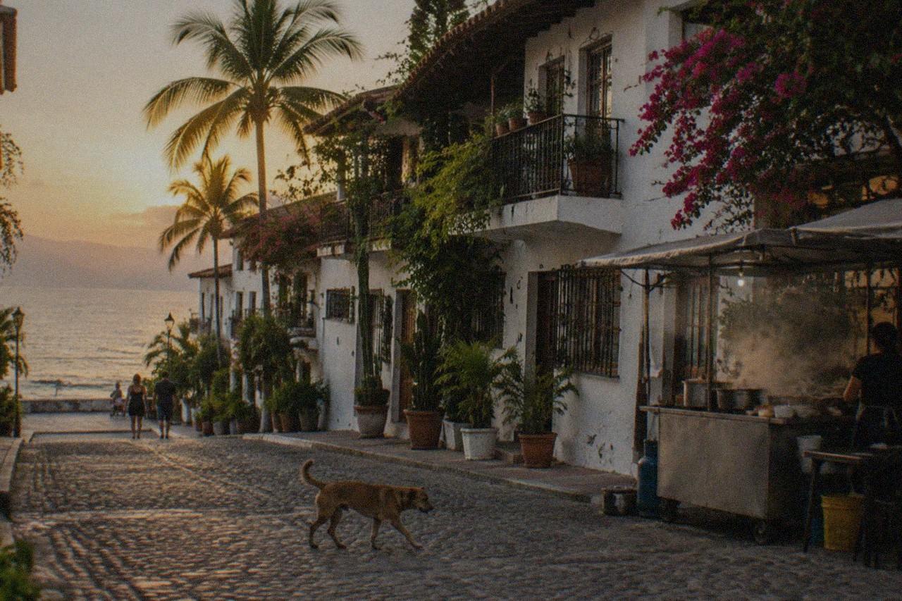 A side street in the Zona Romantica, painted facades above a busy sidewalk taco stand in the evening.