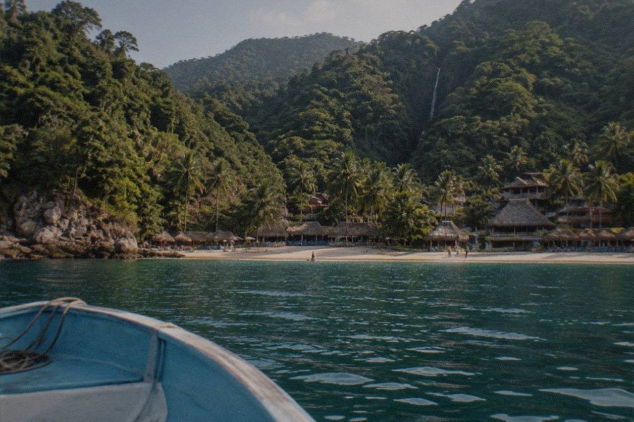 Boats on the sand at Yelapa, the car-free beach village where jungle hills meet Banderas Bay.
